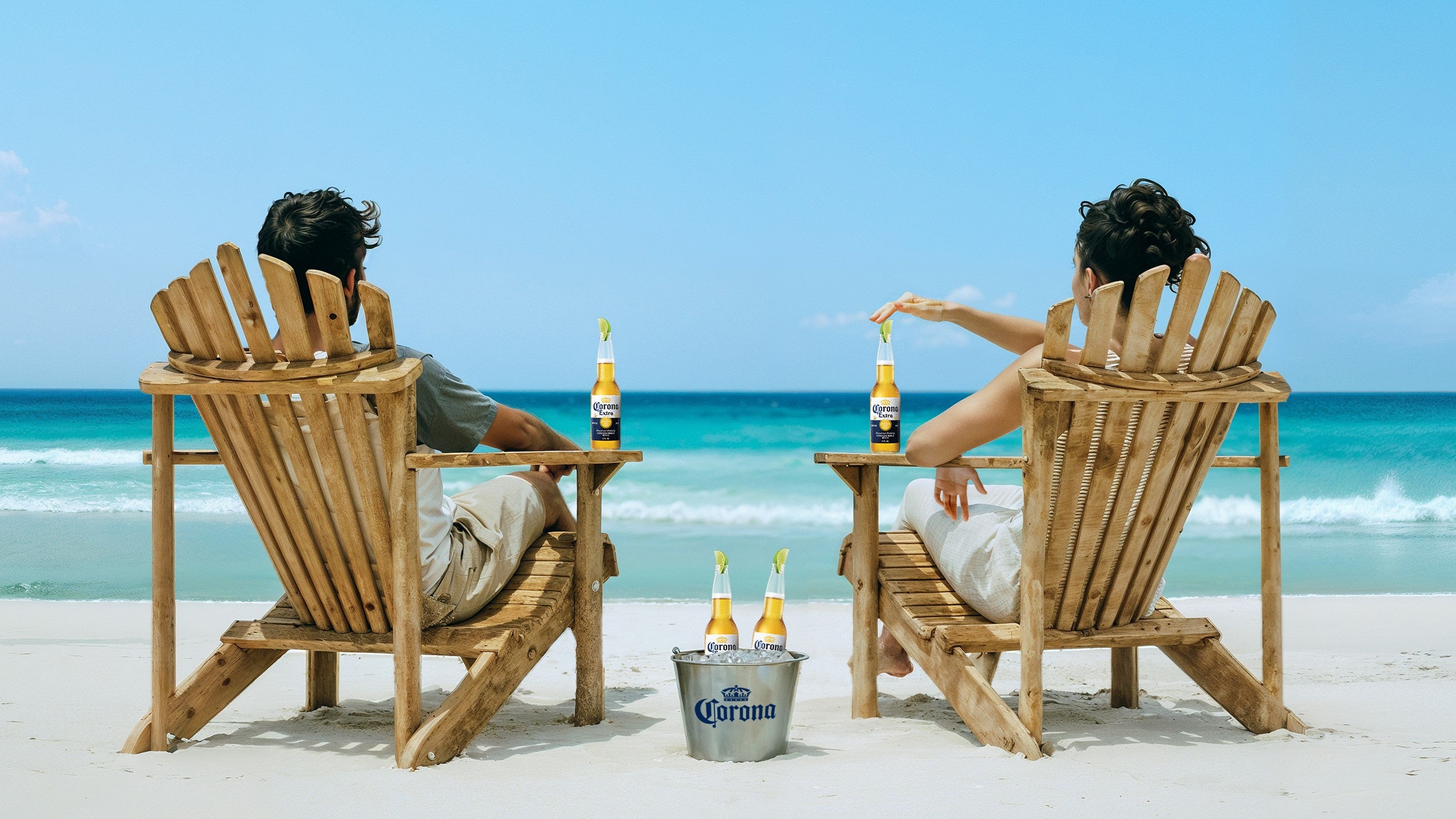 Corona ad featuring two people enjoying Corona Extra on the beach