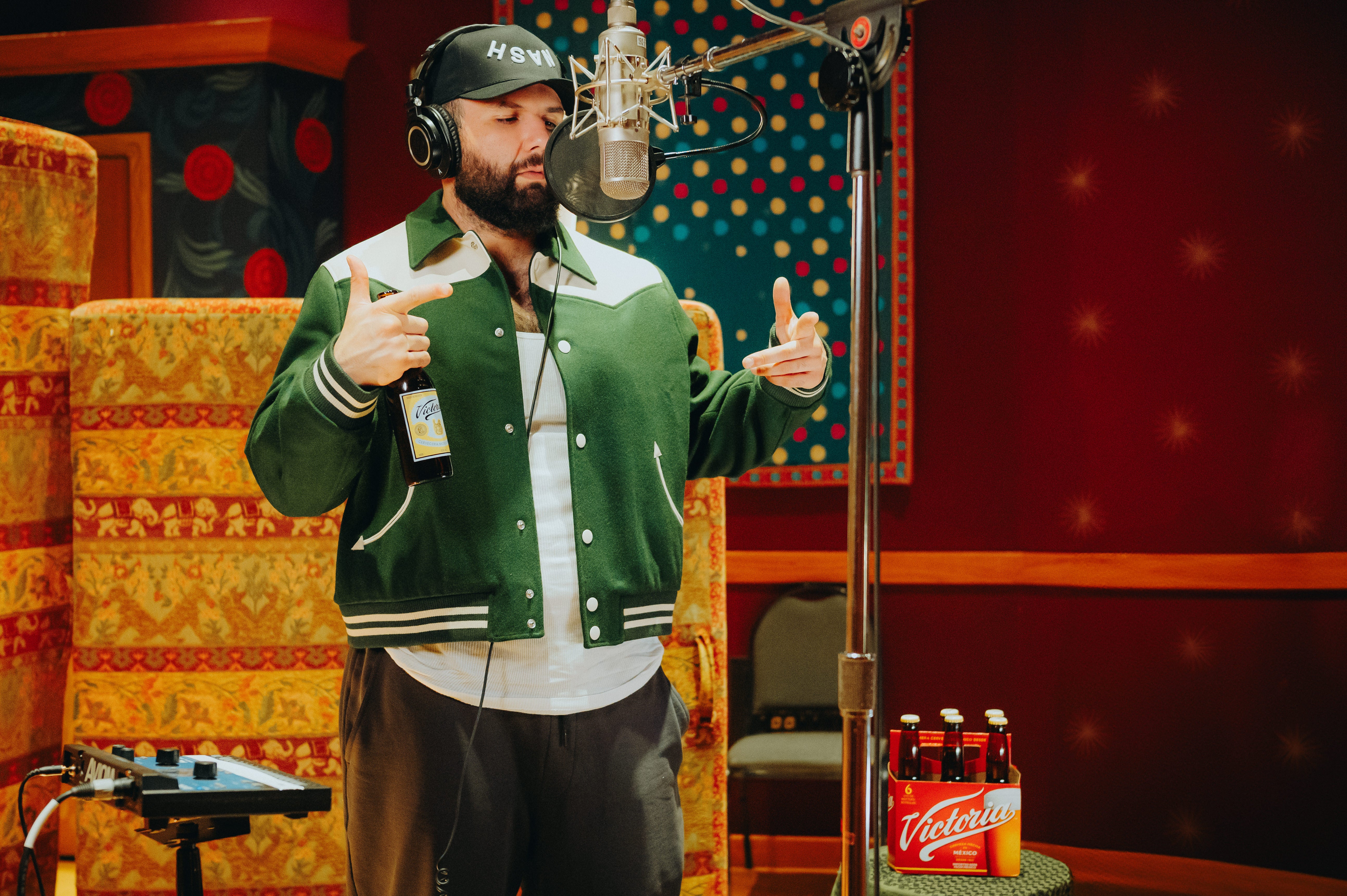 Singer-songwriter Carín León recording music with a Victoria beer in hand