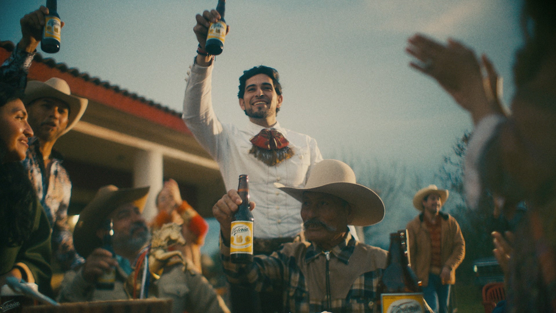 A group of consumers celebrating and holding Victoria beers in hand
